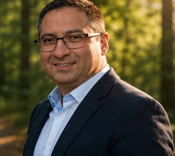 Coach seated outdoors in a sunlit forest